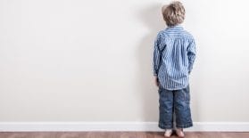 Boy standing against a wall